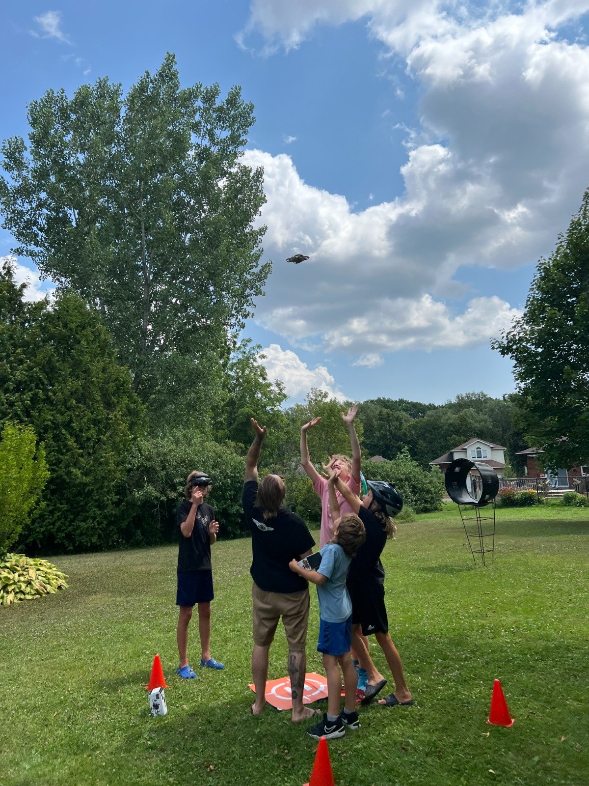 Kids and instructor watching a drone fly at DroneCamp